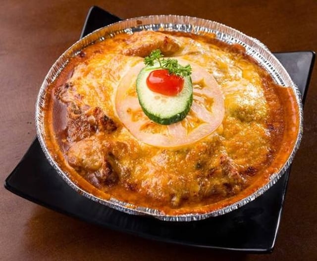 Baked Pork Chop with Cheese over Spaghetti.